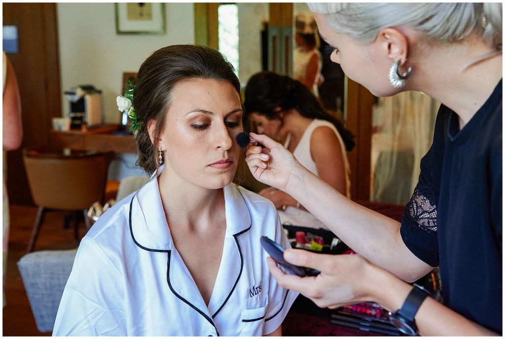 bride having her wedding makeup applied during bridal prep