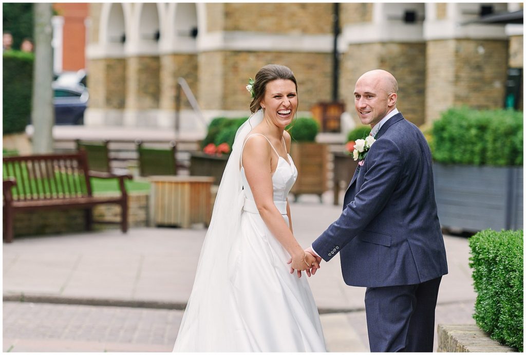 Bride and groom turning around whilst laughing together on their wedding day in East London