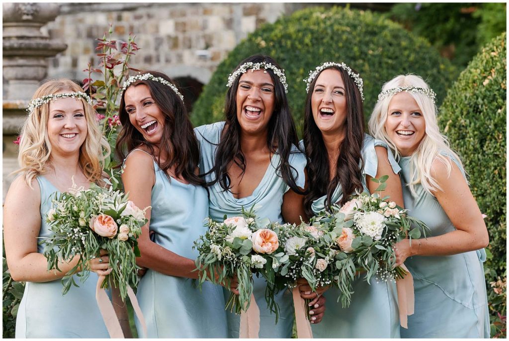 Bridesmaids wearing turquoise dresses laughing together at Castello Di Vincigliata wedding