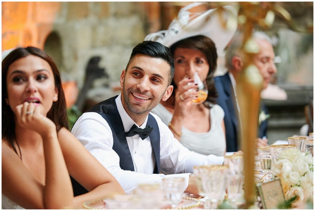 Groom laughing during speeches at Castello Di Vincigliata destination wedding