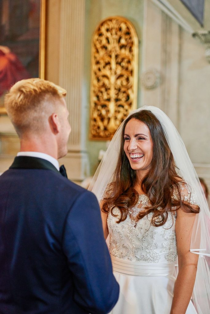 Bride and groom laughing during their wedding ceremony at the Catholic Church of Careggi in Florence, Italy