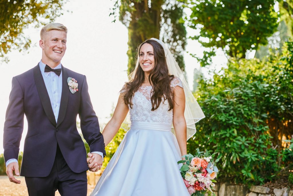 Bride and groom laughing together outside in the sun at villa le Fontanelle