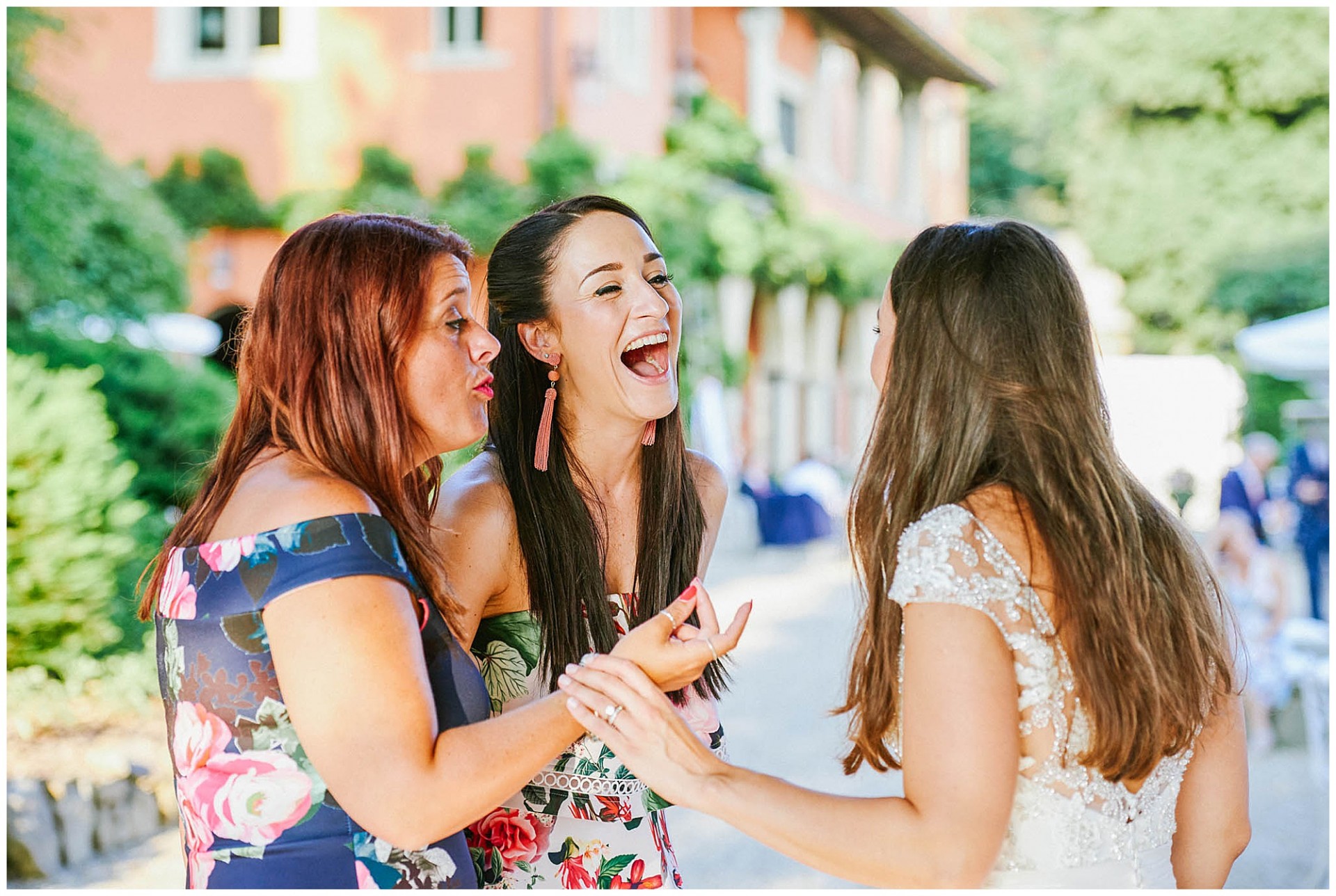 Women laughing together outside at a wedding
