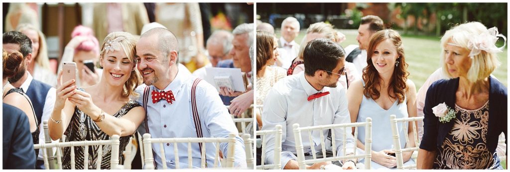vintage looking guests sat outside smiling and socialising during wedding ceremony at Woodhall Manor in Suffolk