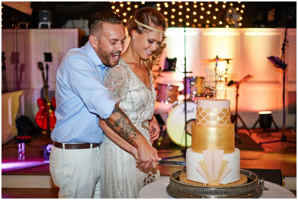 vintage bride & groom cutting wedding cake during Woodhall Manor reception