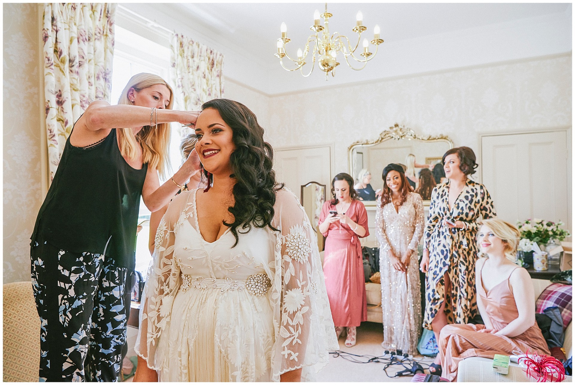 Gorgeous Bride having her hair styled whilst bridesmaids watch.