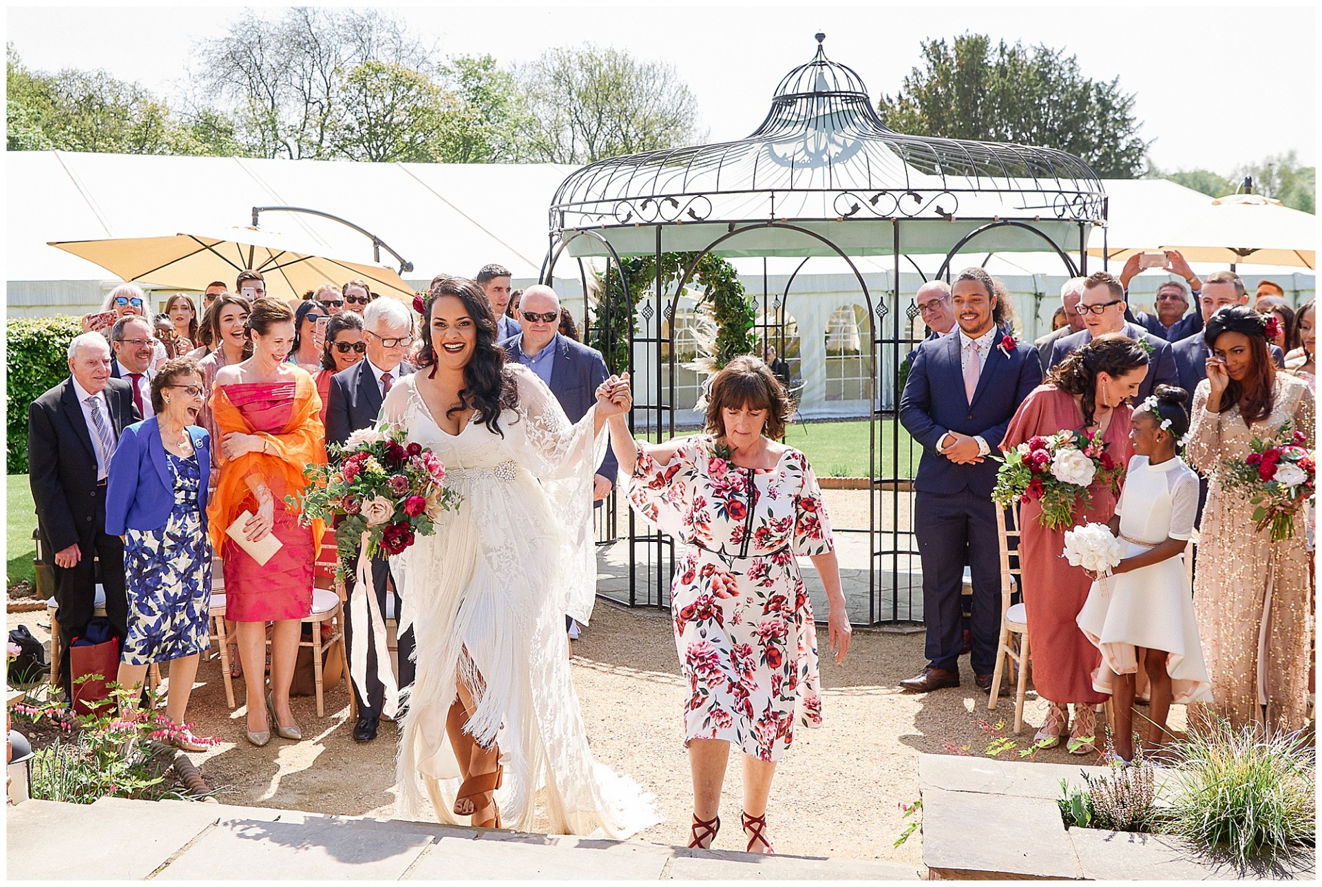 Bride with her mother walking down outdoor wedding aisle at the Walled Garden in Nottingham.