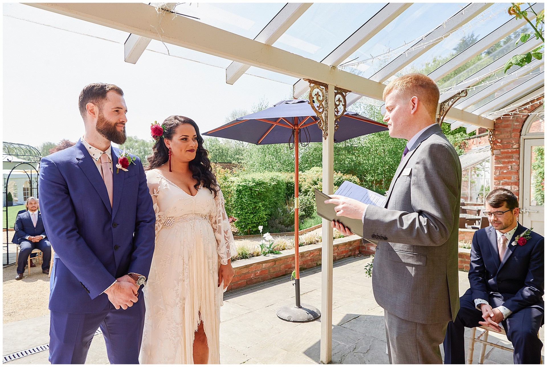 Bride and groom stood under the loggia during their outdoor bohemian wedding ceremony