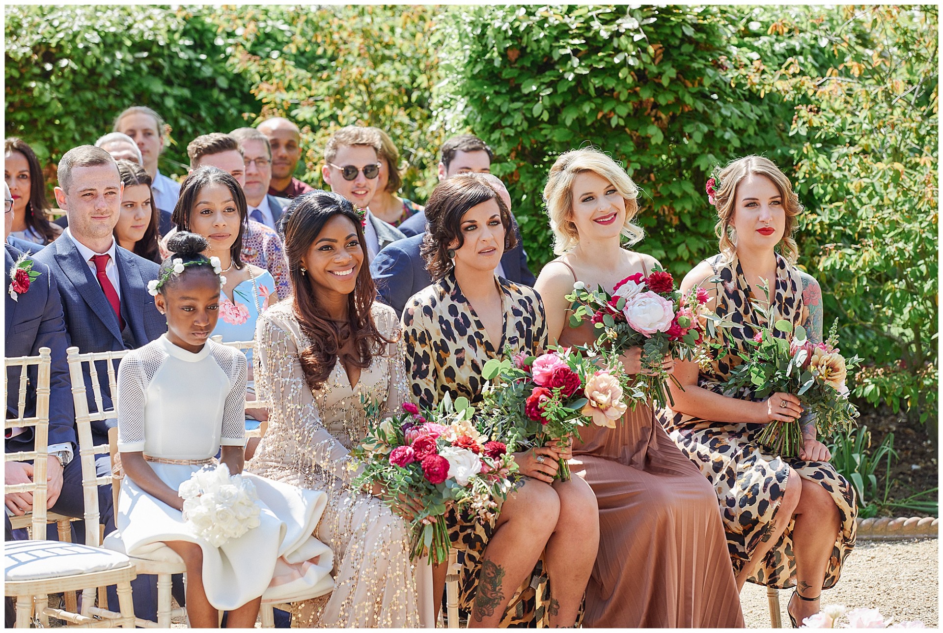 Bridesmaids wearing leopard print dresses during an outdoor wedding at the Walled Garden