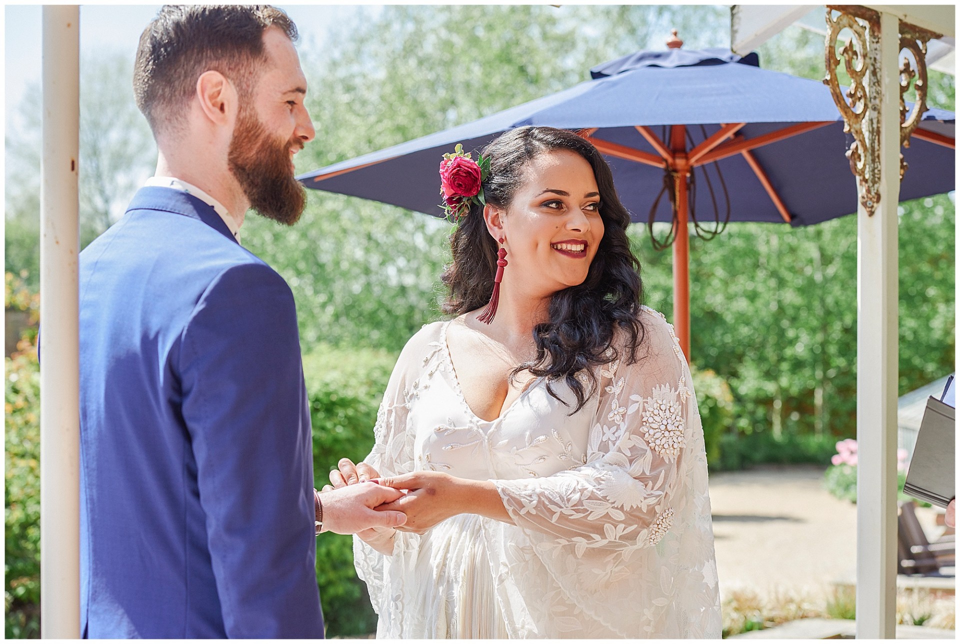 Bohemian bride and groom exchanging rings during outdoor bohemian wedding ceremony