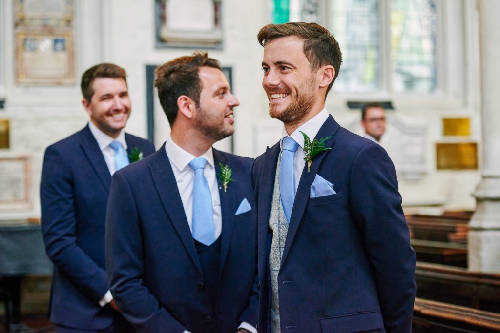 Groom stood at the alter smiling inside St Margaret's Church in central London