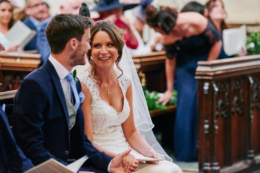 Bride looking at Groom and smiling during ceremony at St Margaret's Church in central London