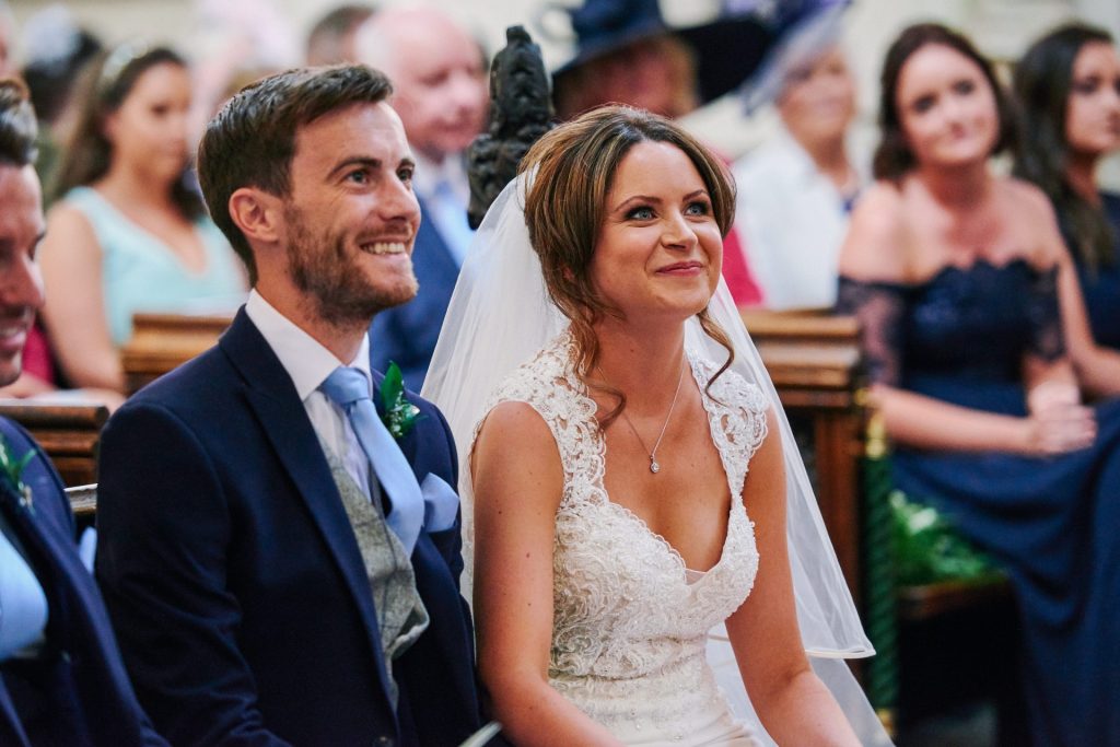 Bride and Groom smiling during ceremony at St Margaret's Church in central London