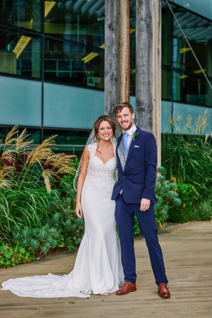 Bride and groom smiling outside of the Oyster Shed riverside wedding venue