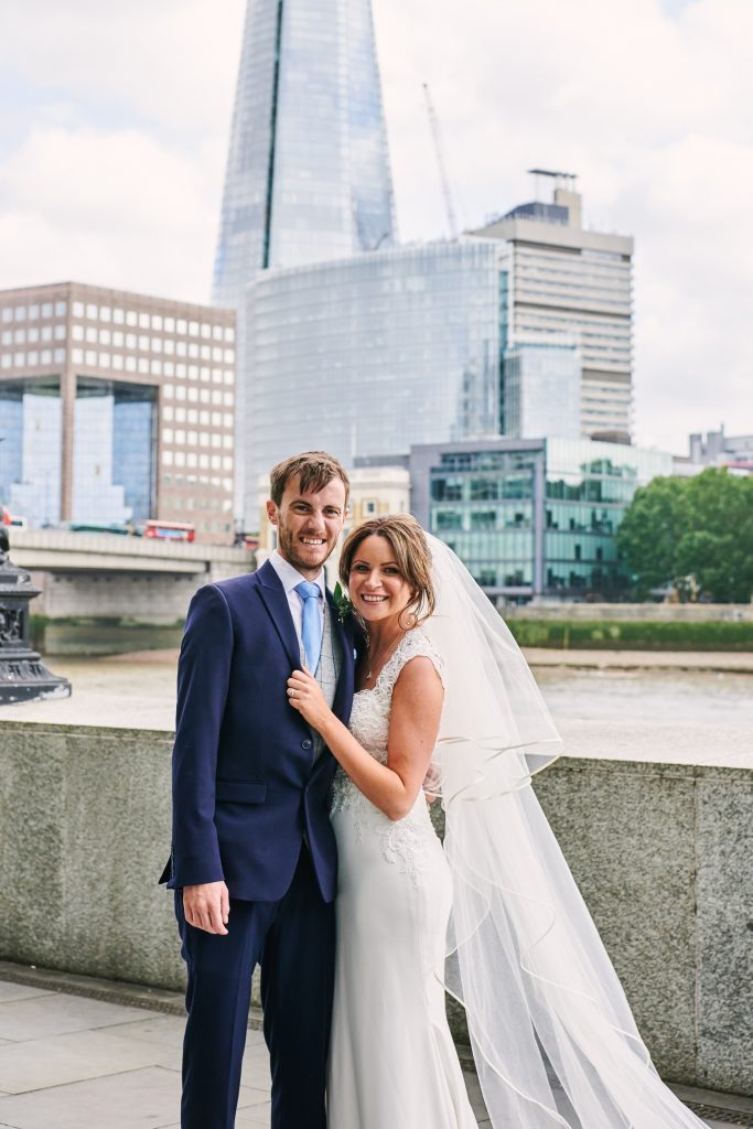 Wedding couple stood in front of The Shard outside of the riverside venue The Oyster Shed