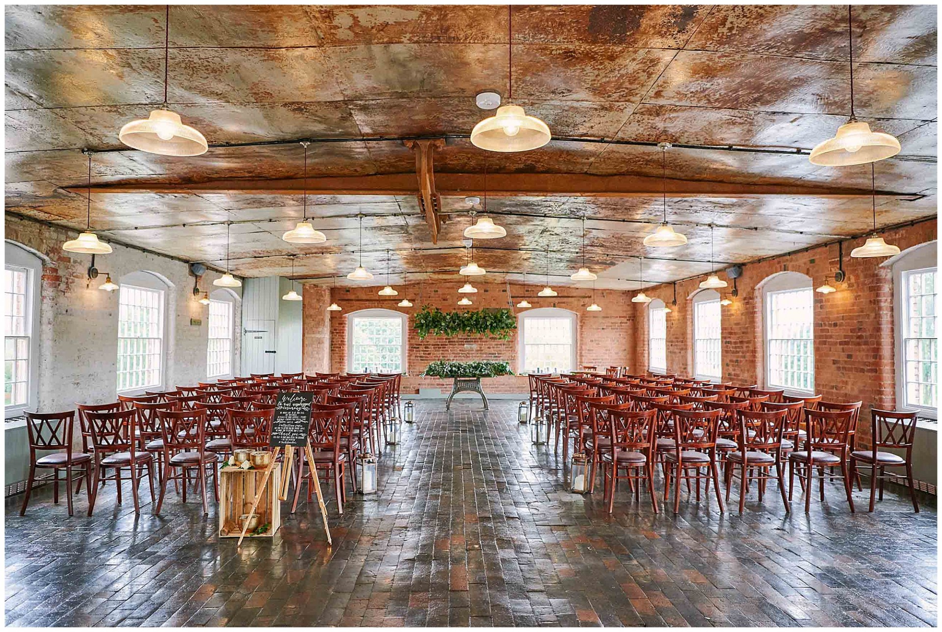 Empty ceremony room with brick walls and metal ceiling at the West Mill Wedding Venue in Derby