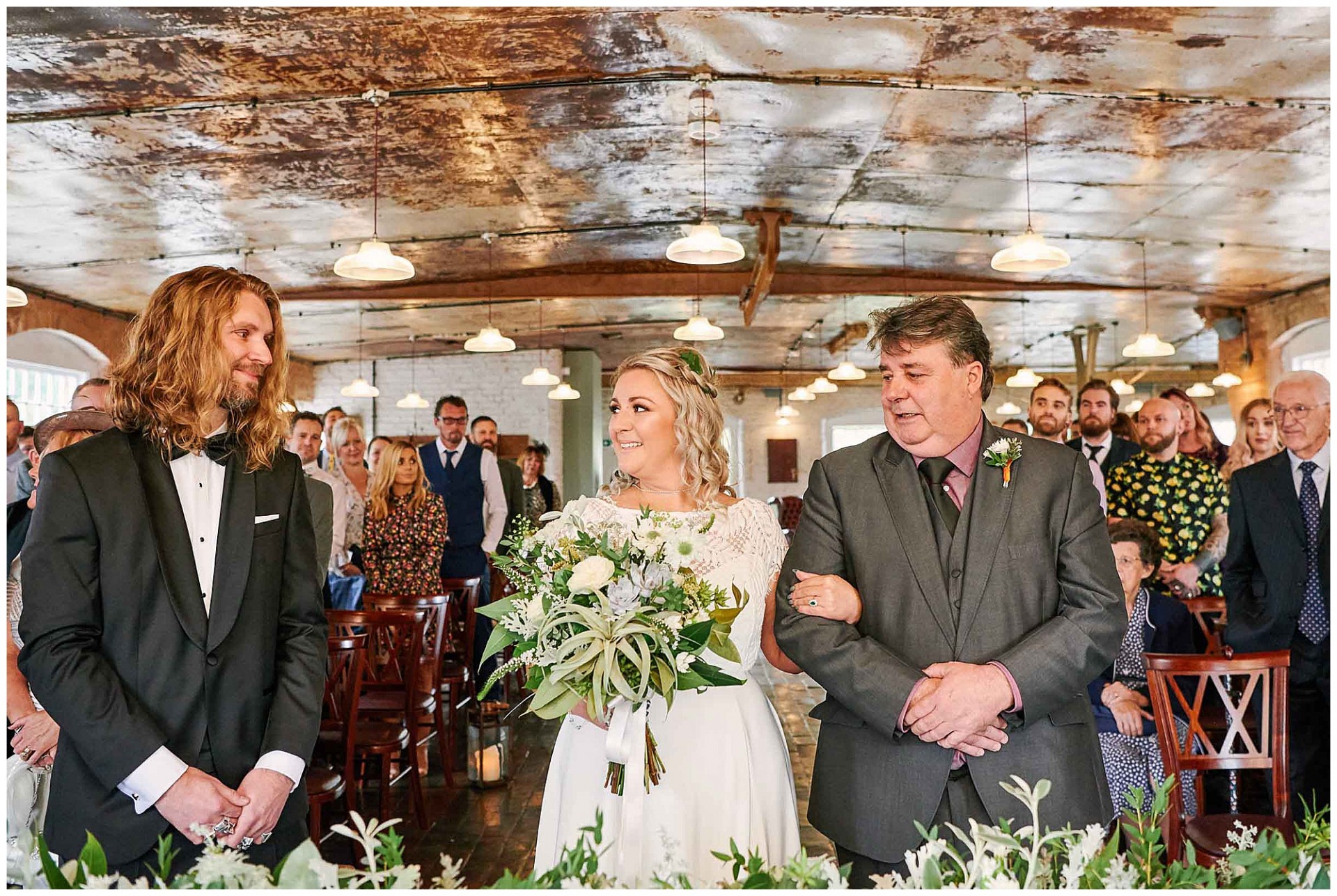 Bride and her father smiling at the groom during a wedding ceremony at the West Mill Venue in Derby