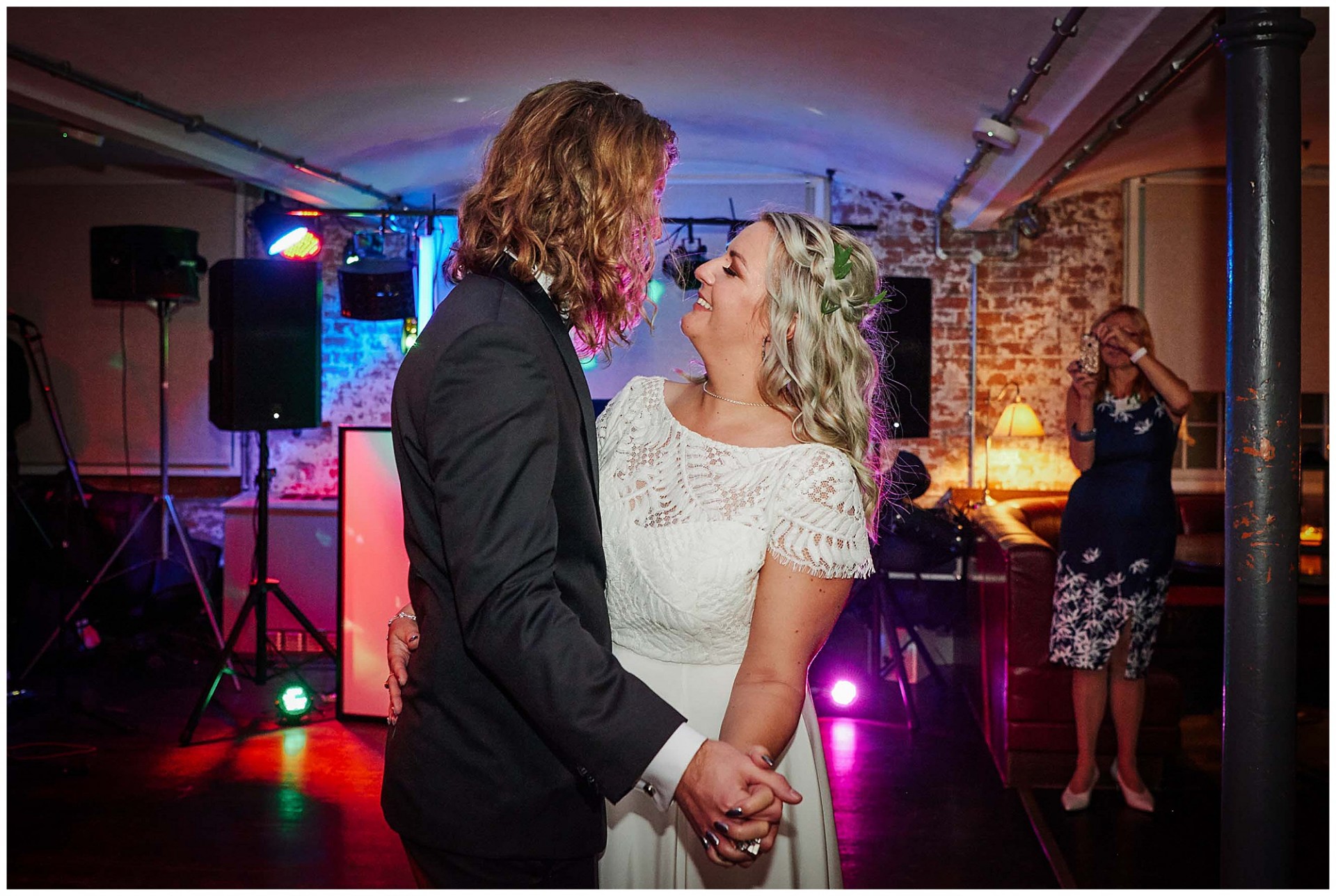 Bride and groom holding hands and dancing during their first dance at The West Mill Wedding Venue in Derby. 