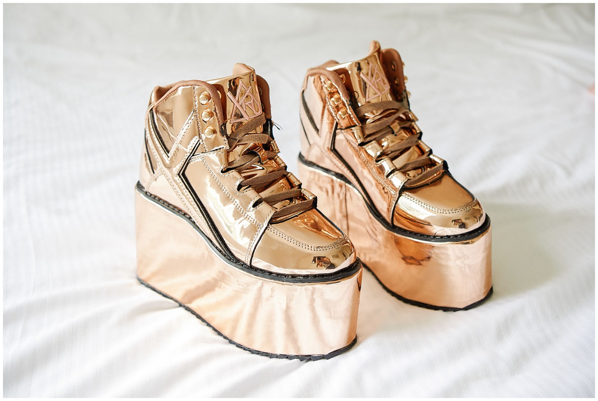 Brides gold platform wedding shoes on a bed