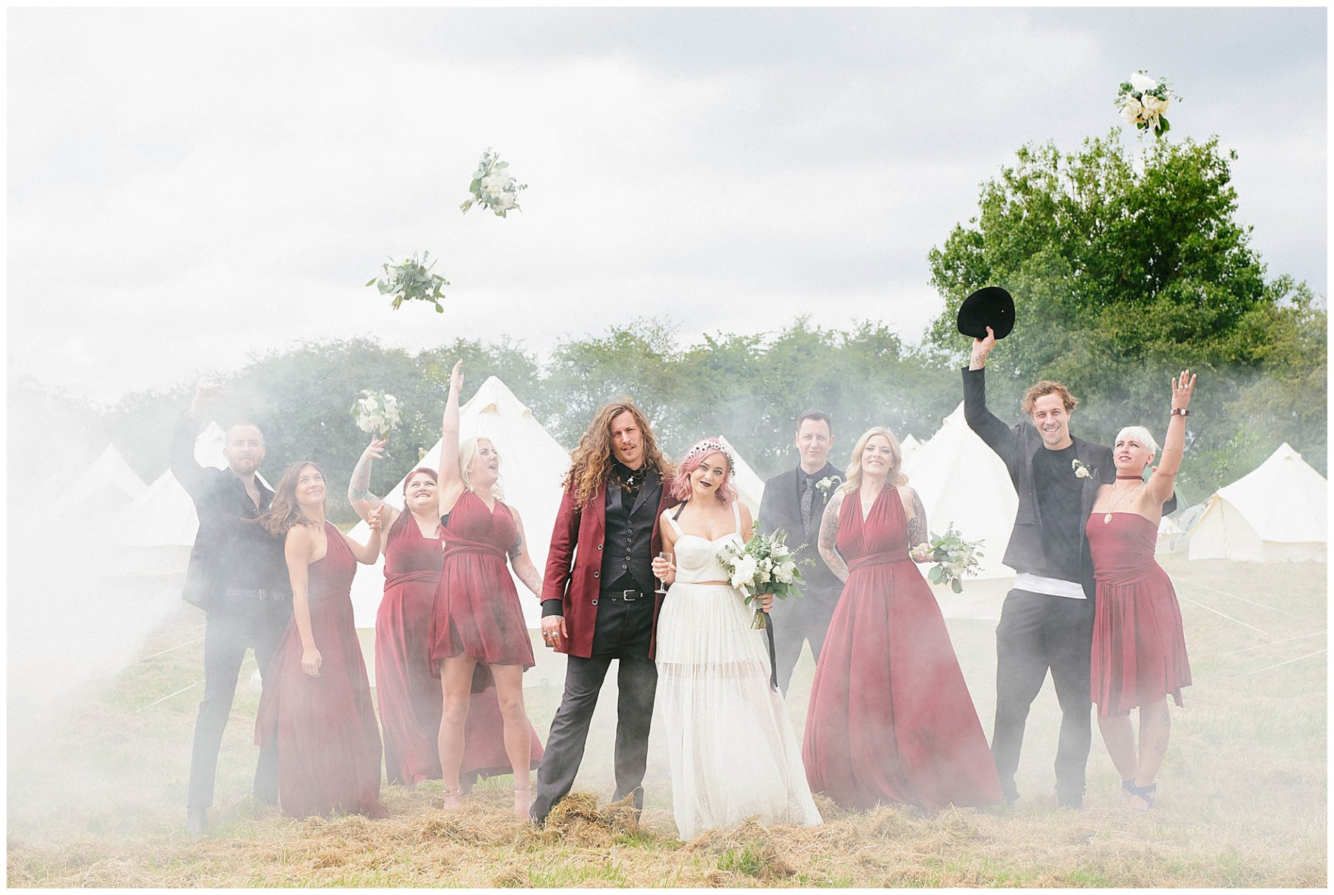 smoke bomb wedding photography in showing bridal party in front of tipis.