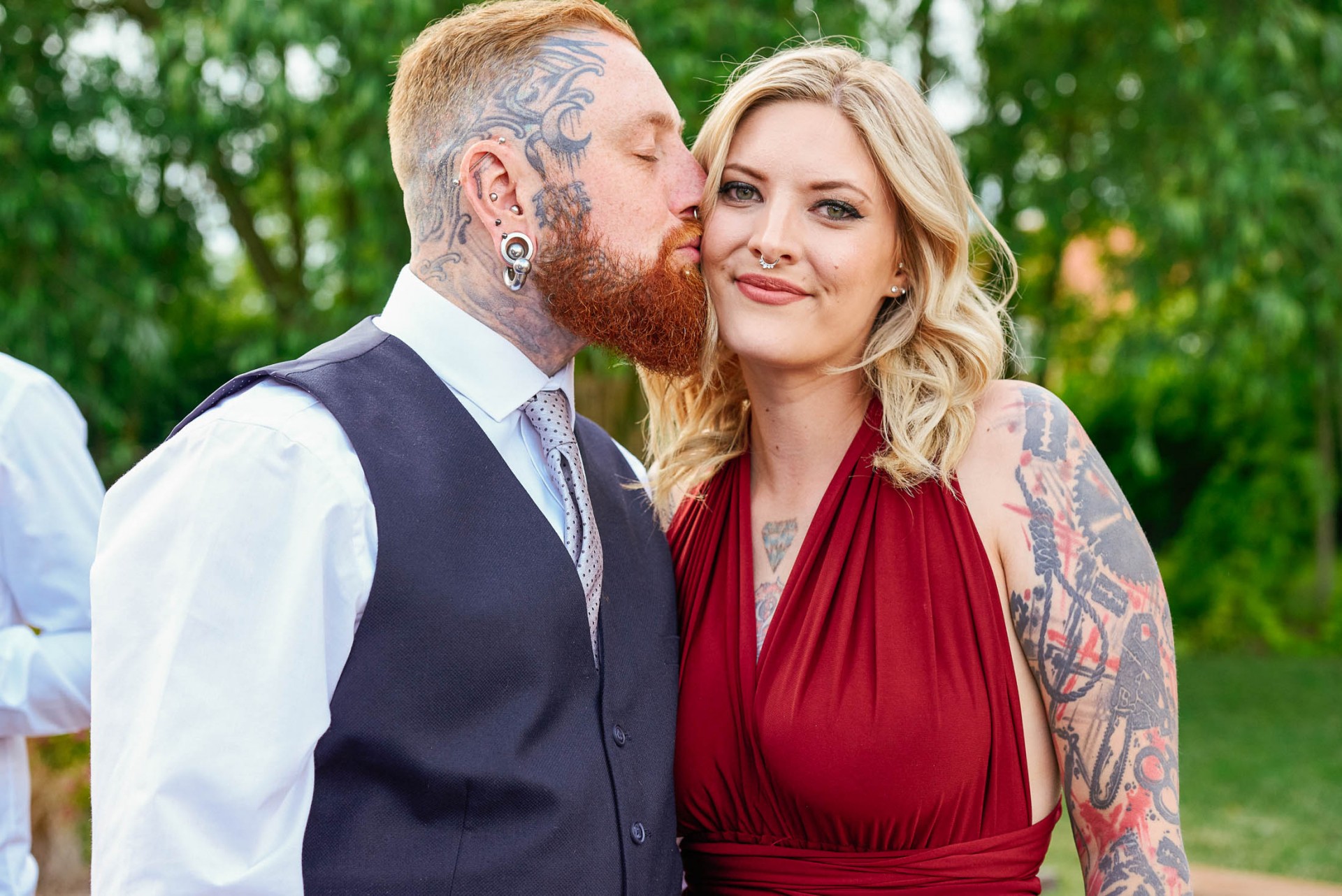 Tattooed wedding couple kissing whilst stood outside at the The Peasantry Brewery