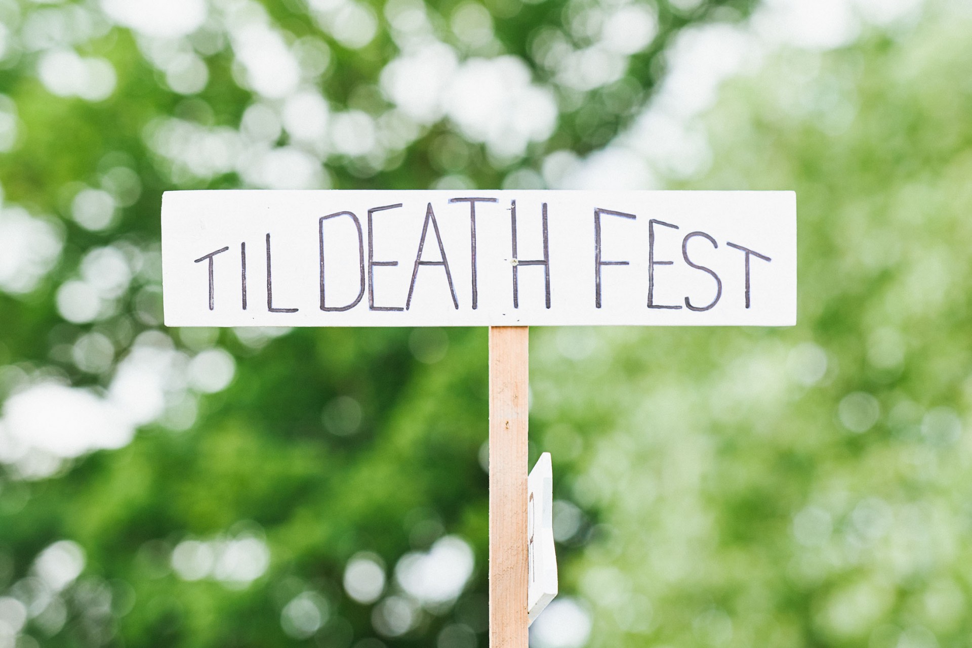 Festival style sign saying 'Till Death Fest' in front of green background 