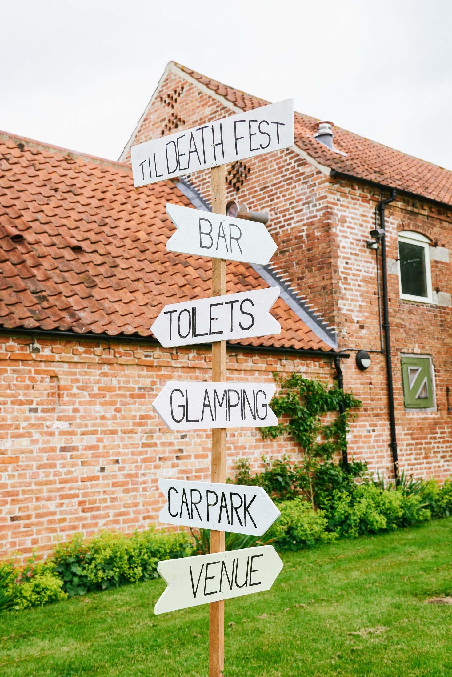 Festival style sign pointing out directions at the The Pheasantry Brewery wedding venue