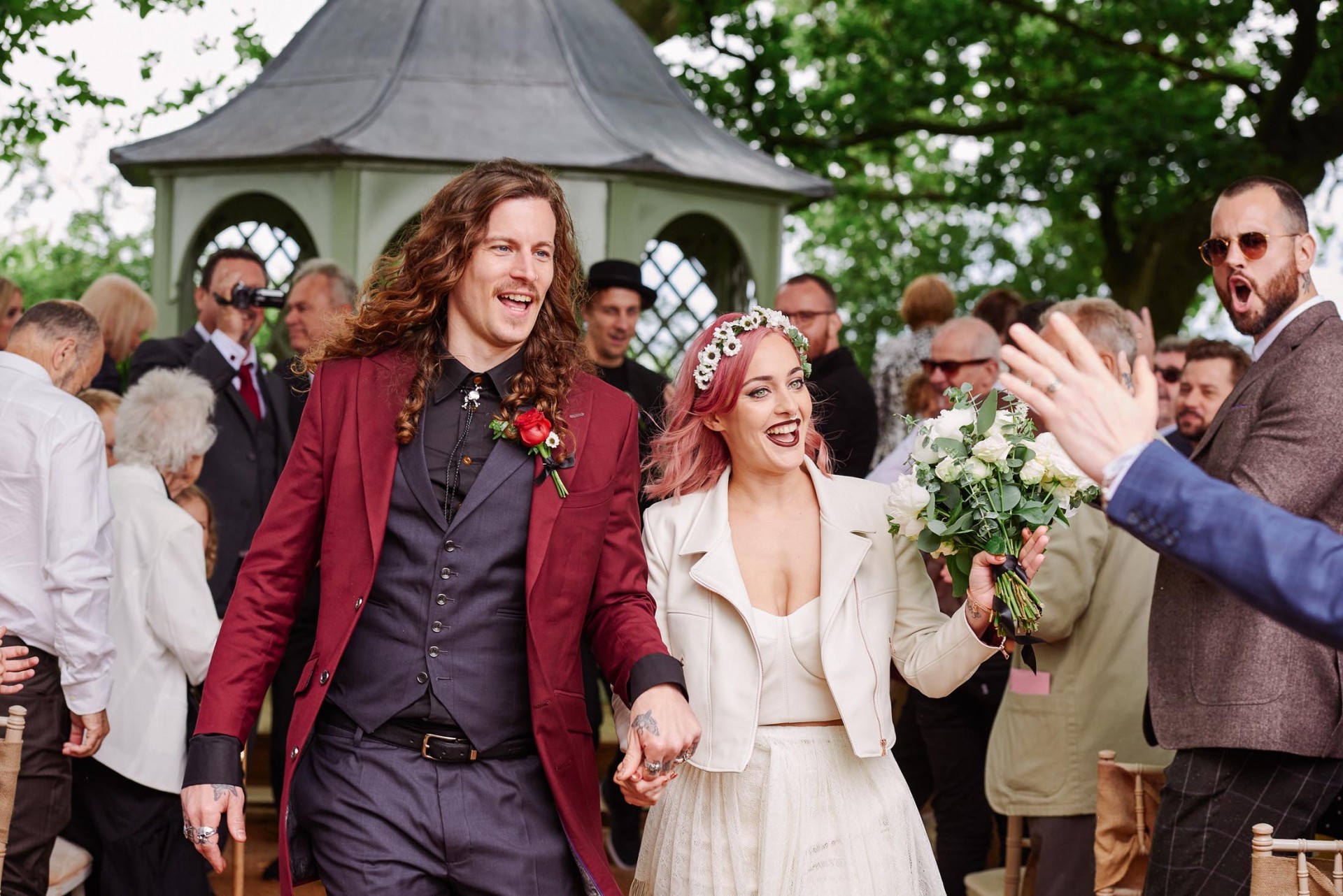 Rock n roll bride & groom walking down aisle during outdoor ceremony at The Pheasantry Brewery.