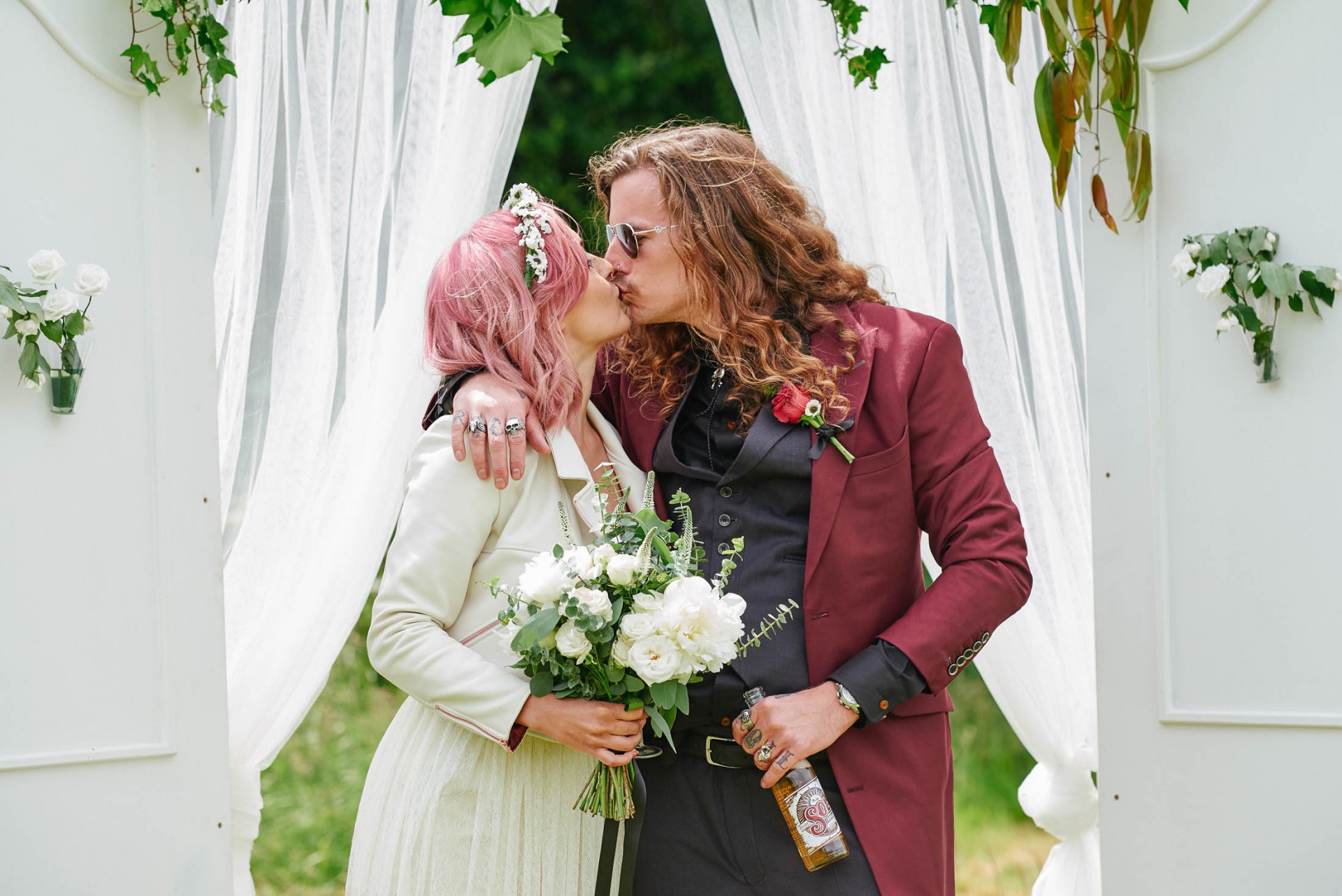 colourful wedding photography featuring alternative bride & groom kissing
