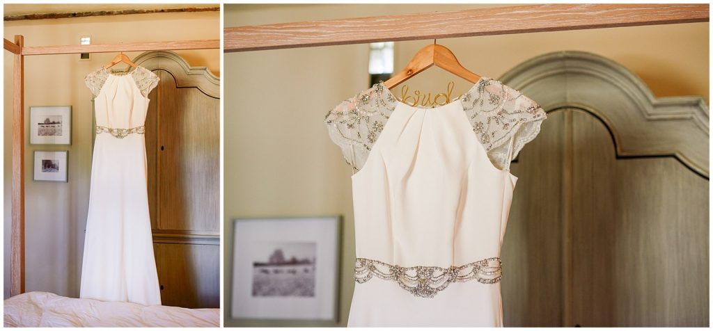 Wedding dress hung on bed in a bridal room in Cambridge