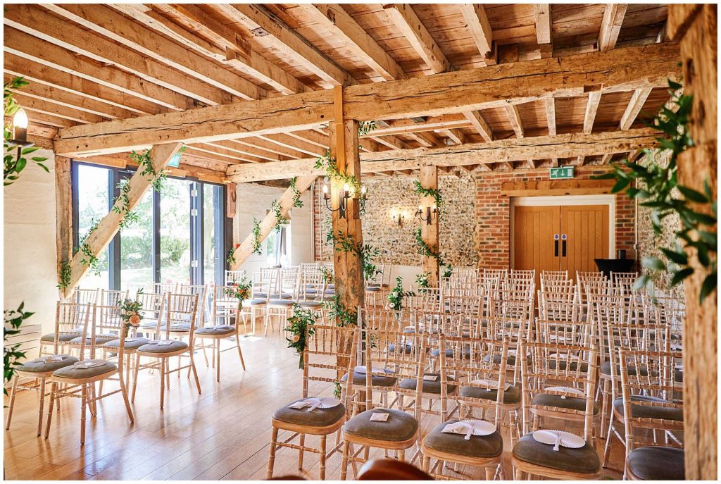 Empty ceremony room with wood beams and brick walls at the rustic looking The Granary Estates barn in Cambridge
