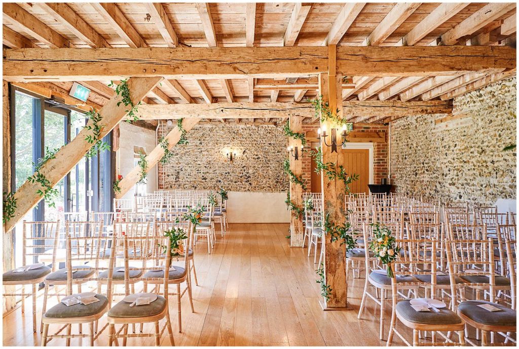 Empty ceremony room with wood beams and brick walls at the rustic looking The Granary Estates barn in Cambridge
