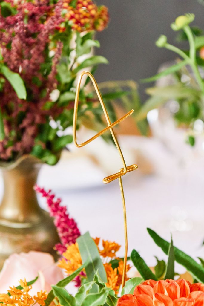 Metal table number four detail in front of flowers