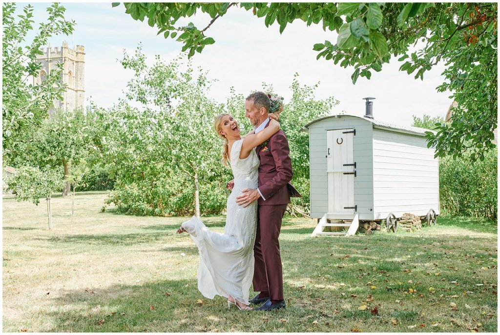 Bride and groom pulling fun pose during their outdoor couples shoot at The Almonry Barn