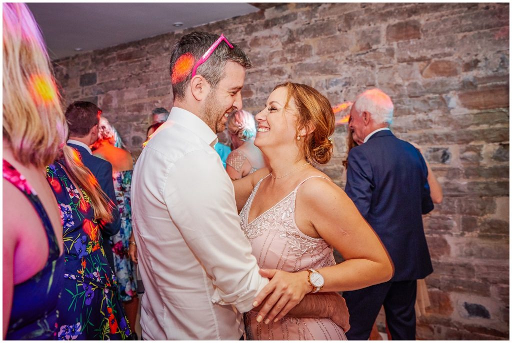 Fun wedding guests dancing in an old stone barn