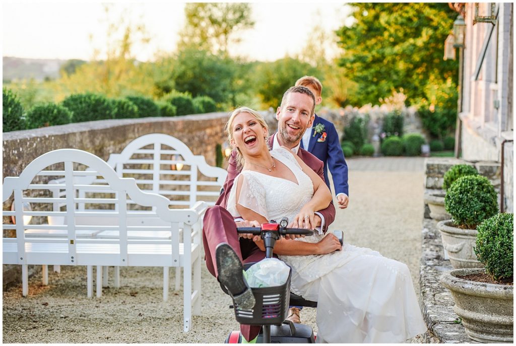 Bride and groom having fun on a mobility scooter at fun wedding