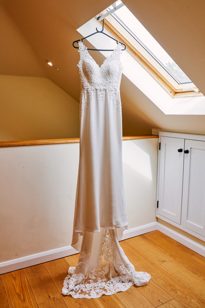 Wedding dress hung up in a barn room at Micklefield Hall