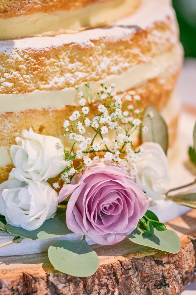 Detail shot of beautiful layered sponge wedding cake with pink roses