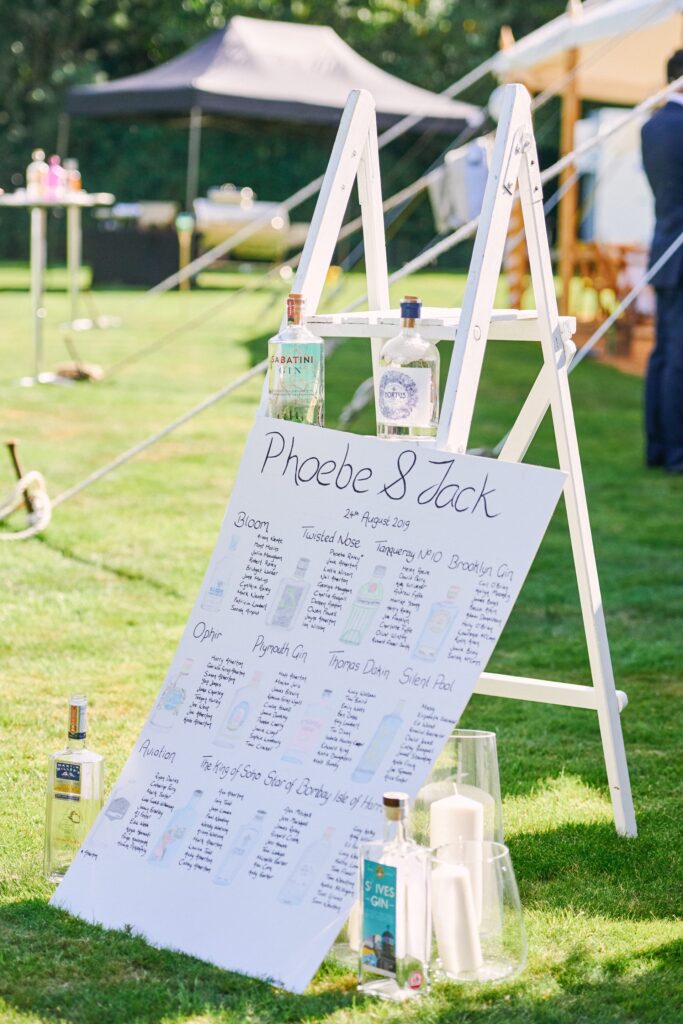 Gin themed table plan at festival style summer wedding