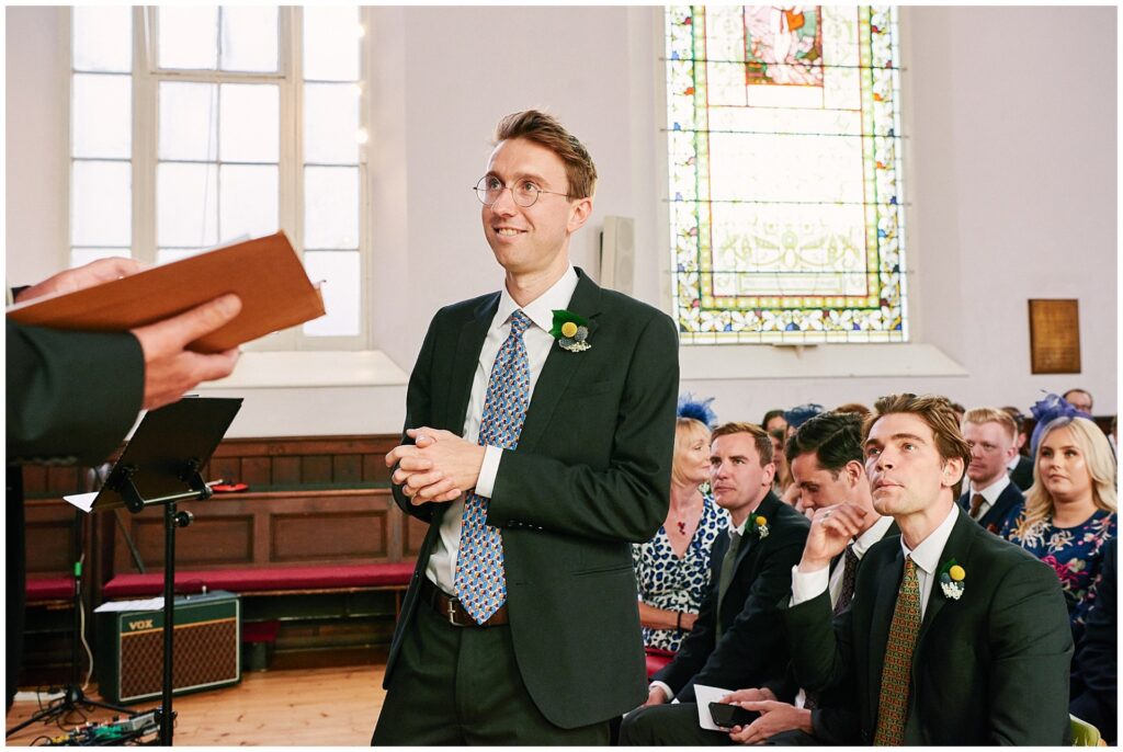 Groom smiling as he waits at the alter in Brighton Unitarian Church