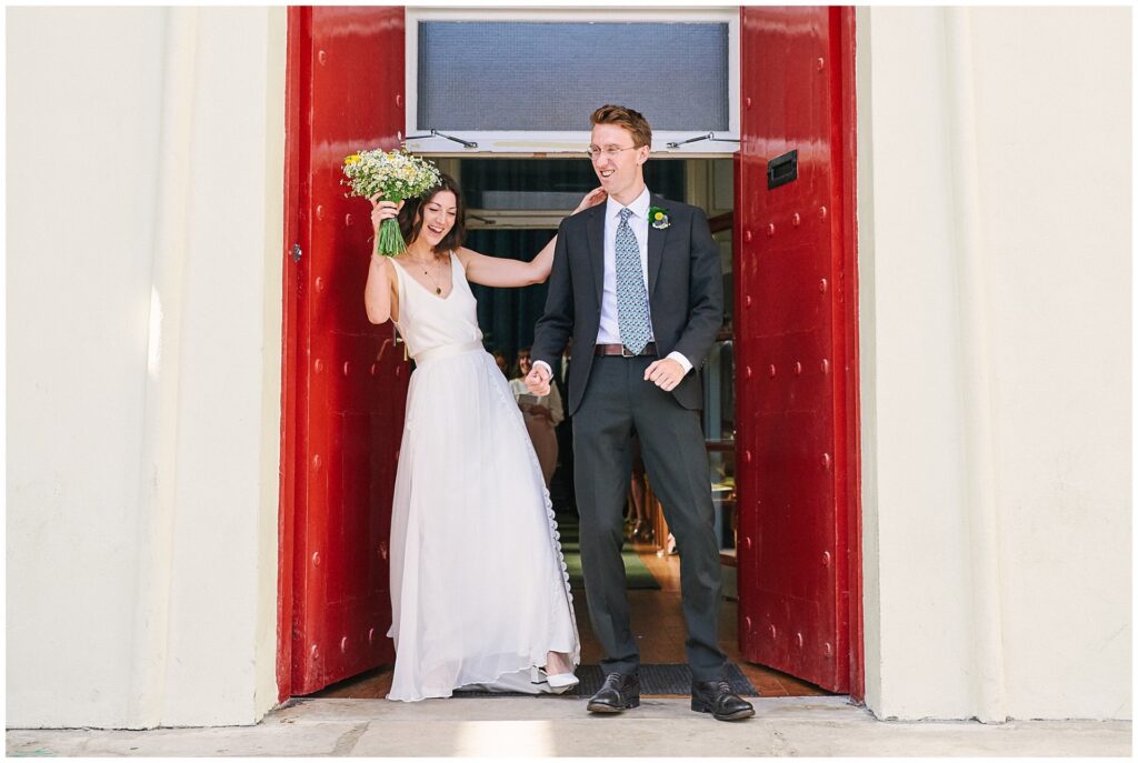 Bride and groom celebrating as they exit Brighton Unitarian Church