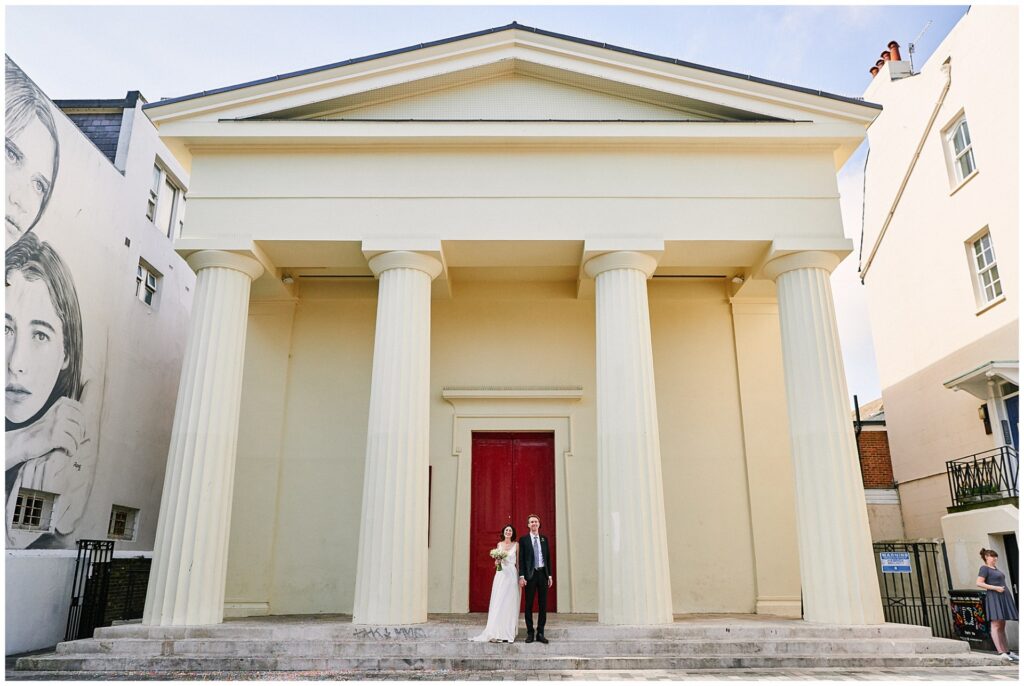 Laid back Bride and groom stood outside of Brighton Unitarian Church