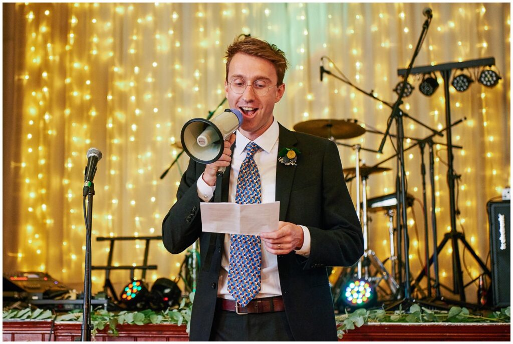 Groom giving his speech using a megaphone at Brighton wedding reception. 