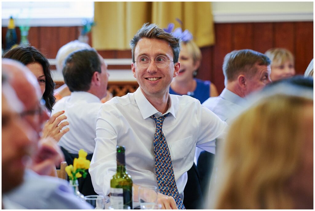 laid back groom laughing during wedding speeches in Brighton.