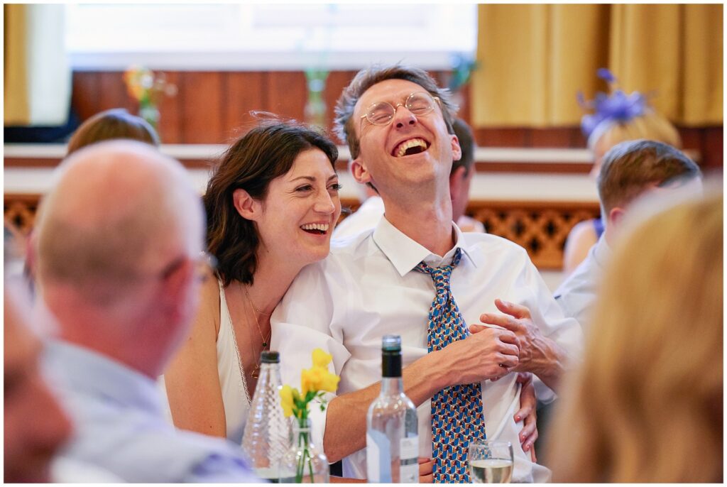 Bride and Groom laughing during wedding dinner speeches in Brighton. 