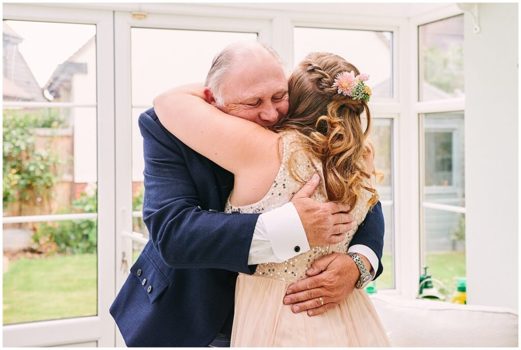 Father and bride hugging each other during bridal prep in Essex