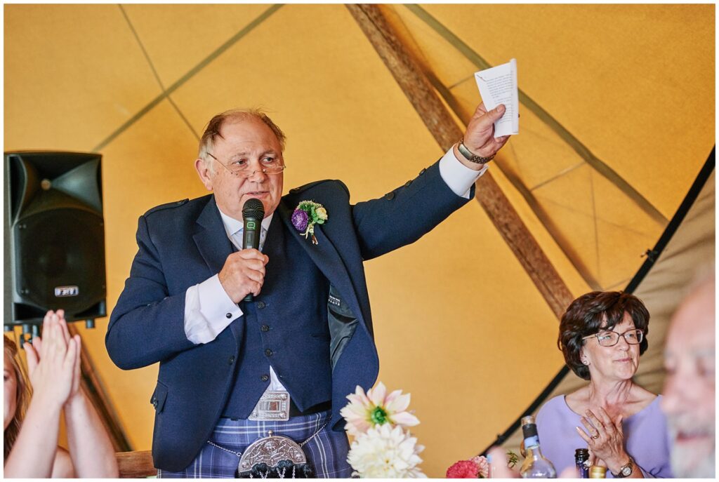 Father of the bride giving a speech inside a festival tipi tent in Essex