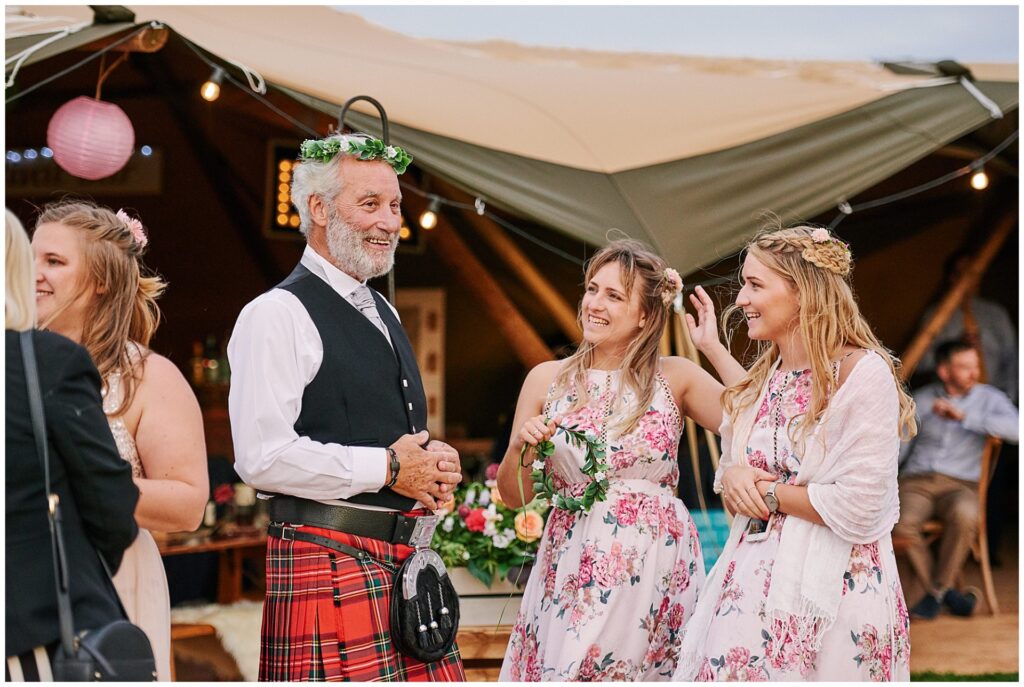 Scottish father of the bride laughing with flower crown on his head