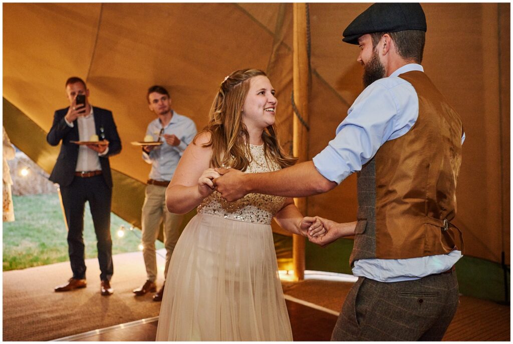 wedding couple dancing together in a festival tipi in Essex