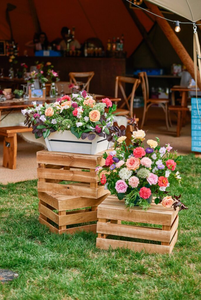 flower details on wooden crates at relaxed festival wedding
